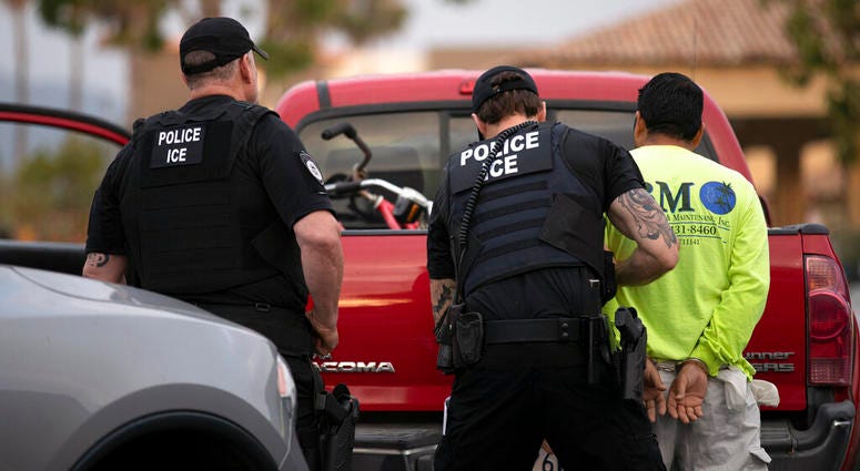In this July 8, 2019 file photo, U.S. Immigration and Customs Enforcement (ICE) officers detain a man during an operation in Escondido, Calif AP DO NOT USE