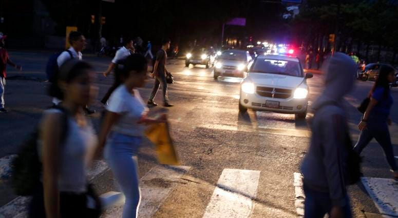 People cross a street during a blackout in Caracas, Venezuela, Monday, July 22, 2019. AP DO NOT USE