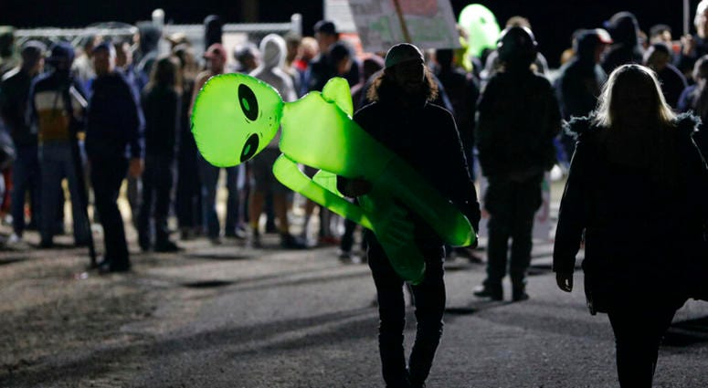 A mans holds an inflatable alien at an entrance to the Nevada Test and Training Range near Area 51 Friday, Sept. 20, 2019, near Rachel, Nev. AP DO NOT USE