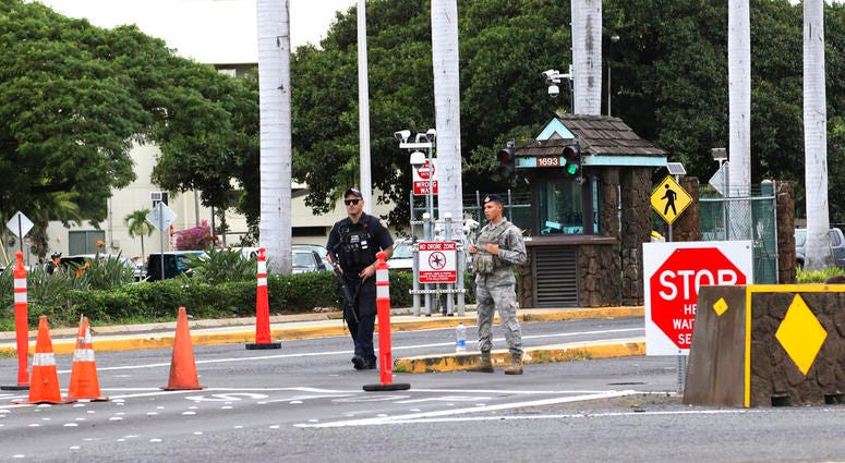 Security stand outside the main gate at Joint Base Pearl Harbor-Hickam, Wednesday, Dec. 4, 2019, in Hawaii. A shooting at Pearl Harbor naval shipyard in Hawaii left at least one person injured Wednesday, military and hospital officials said. Security stand outside the main gate at Joint Base Pearl Harbor-Hickam, Wednesday, Dec. 4, 2019, in Hawaii. A shooting at Pearl Harbor naval shipyard in Hawaii left at least one person injured Wednesday, military and hospital officials said.