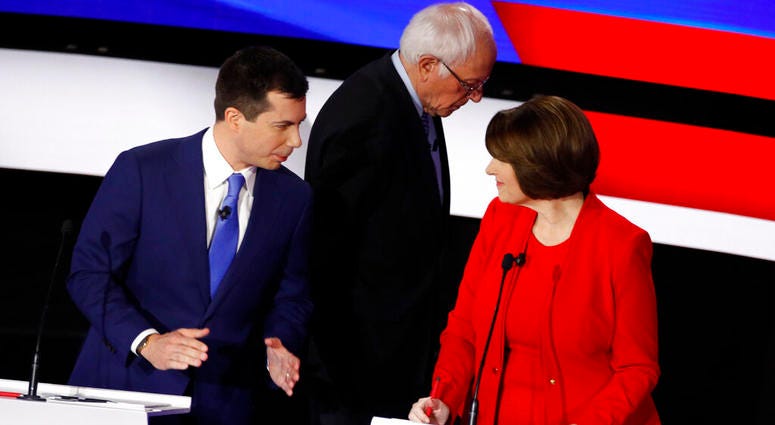 Democratic presidential candidates former South Bend Mayor Pete Buttigieg, left, and Sen. Amy Klobuchar, D-Minn., talk while Sen. Bernie Sanders, I-Vt., heads off stage at a break Tuesday, Jan. 14, 2020, during a Democratic presidential primary debate hos AP DO NOT USE