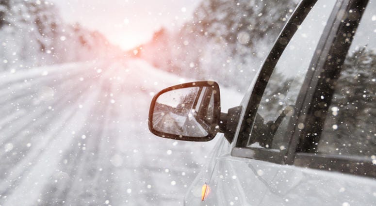 The winter road is reflected in the car's rear-view mirror The winter road is reflected in the car's rear-view mirror