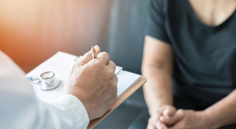 Geriatric doctor (geriatrician) consulting and diagnostic examining elderly senior adult patient
