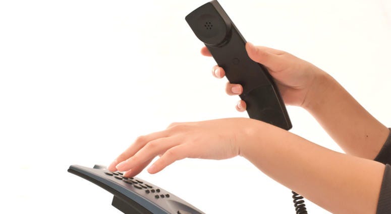 person dialing telephone
