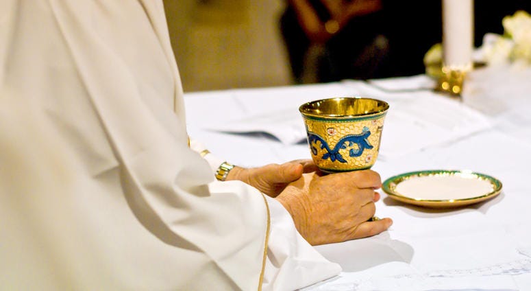 Priest with chalice Priest at Church