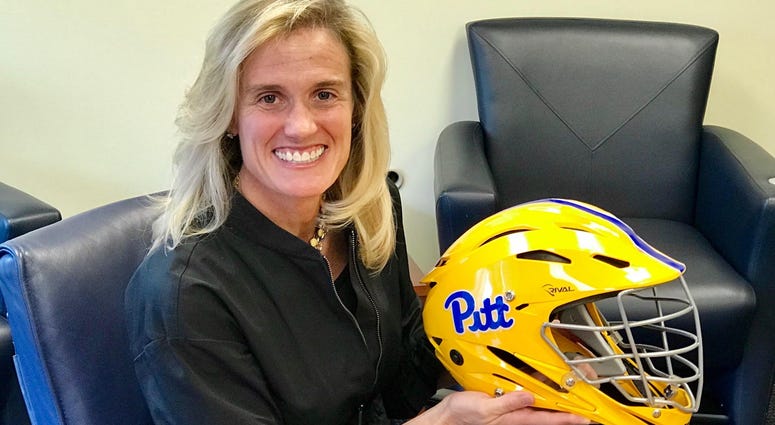 Pitt AD Heather Lyke with women's lacrosse goalie helmet in 2018