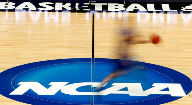 a player runs across the NCAA logo during practice at the NCAA tournament college basketball in Pittsburgh a player runs across the NCAA logo during practice at the NCAA tournament college basketball in Pittsburgh