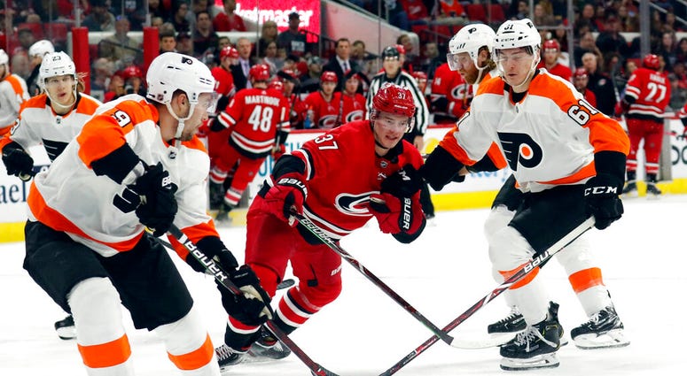 Philadelphia Flyers' Ivan Provorov (9) of Russia and Philippe Myers (61) battle Carolina Hurricanes' Andrei Svechnikov (37) of Russia for the puck during the third period of an NHL hockey game in Raleigh, N.C. on Saturday, March 30, 2019. Philadelphia Flyers' Ivan Provorov (9) of Russia and Philippe Myers (61) battle Carolina Hurricanes' Andrei Svechnikov (37) of Russia for the puck during the third period of an NHL hockey game in Raleigh, N.C. on Saturday, March 30, 2019.