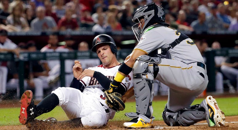 Arizona Diamondbacks' John Ryan Murphy is tagged out by Pittsburgh Pirates catcher Elias Diaz while trying to score on a base hit by Chris Owings during the second inning DO NOT USE