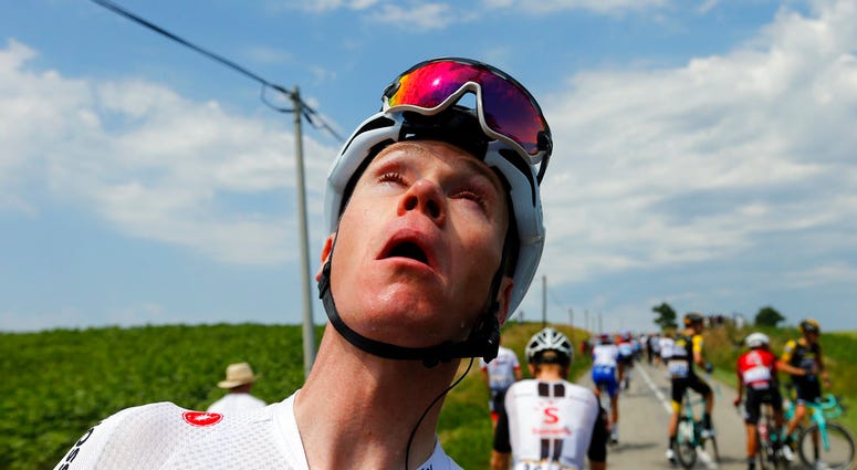Britain's Chris Froome grimaces after being treated for tear gas or pepper spray sprayed on the peloton when a farmer's protest interrupted during the sixteenth stage of the Tour de France cycling race DO NOT USE