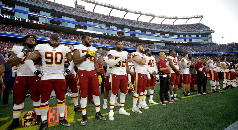Washington Redskins players stand for the national anthem before a preseason NFL football game against the New England Patriots, Thursday, Aug. 9, 2018, in Foxborough, Mass. DO NOT USE