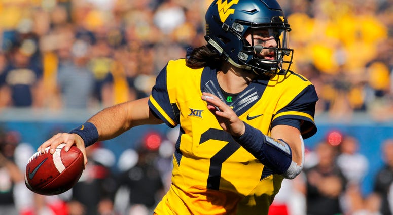 In this Oct. 14, 2017, file photo, West Virginia quarterback Will Grier (7) rolls out during an NCAA college football game, in Morgantown DO NOT USE