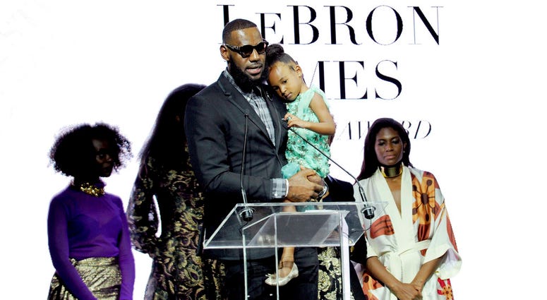 Basketball star LeBron James, holds his daughter Zhuri, as he accepts the Harlem Fashion Row's ICON 360 Award for his contribution to fashion and philanthropy at the HFR fashion show and awards ceremony before the start of New York Fashion Week DO NOT USE