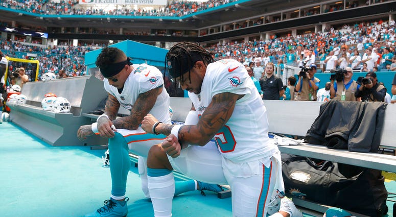 Miami Dolphins wide receiver Kenny Stills (10) and Miami Dolphins wide receiver Albert Wilson (15) kneel during the national anthem before an NFL football game against the Tennessee Titans, Sunday, Sept. 9, 2018, in Miami Gardens, Fla. DO NOT USE