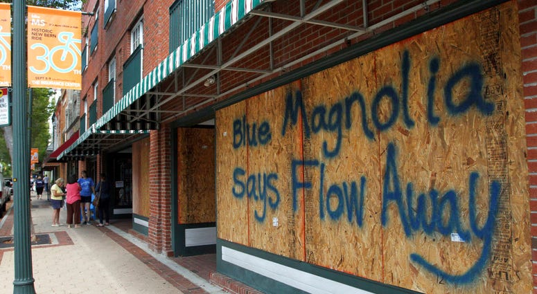 Storefronts have wood paneling installed over windows, Tuesday, Sept. 11, 2018, in New Bern, N.C., as a precaution against storm damage from Hurricane Florence. DO NOT USE