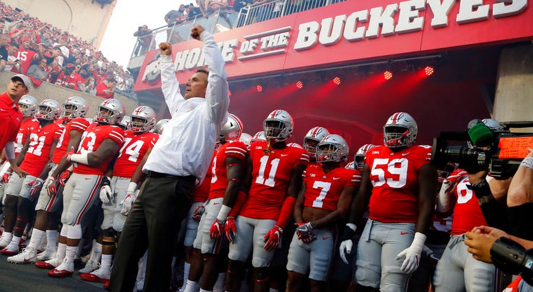 file photo, Ohio State head coach Urban Meyer leads his team onto the field before an NCAA college football game against Oklahoma in Columbus, Ohio. DO NOT USE