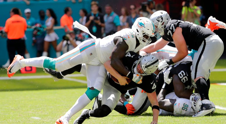 In this Sunday, Sept. 23, 2018, file photo, Miami Dolphins defensive end William Hayes (95) sacks Oakland Raiders quarterback Derek Carr DO NOT USE