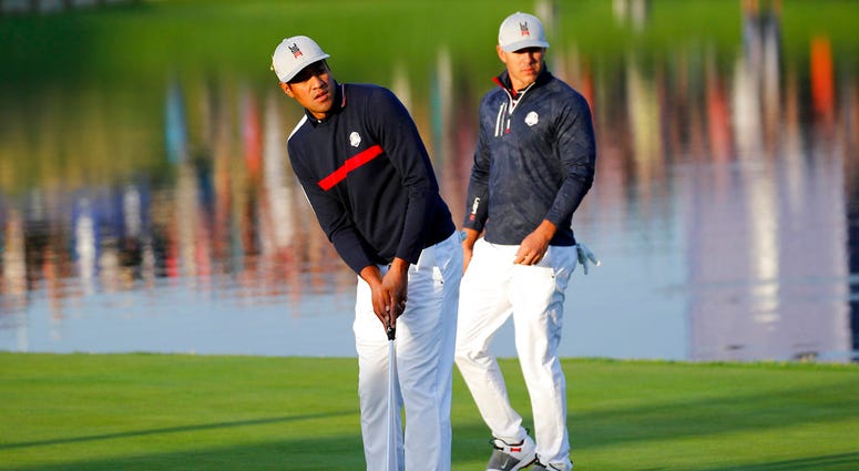 ony Finau of the US putts on the 2nd green while his teammate Brooks Koepka, right, looks on during their foursome match against Europe players Justin Rose and Jon Rahm on the opening day of the 42nd Ryder Cup DO NOT USE