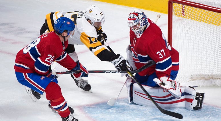 Pittsburgh Penguins' Bryan Rust (17) moves in on Montreal Canadiens goaltender Antti Niemi as Canadiens' Noah Juulsen defends during the third period of an NHL hockey game, Saturday, Oct. 13, 2018 in Montreal. DO NOT USE