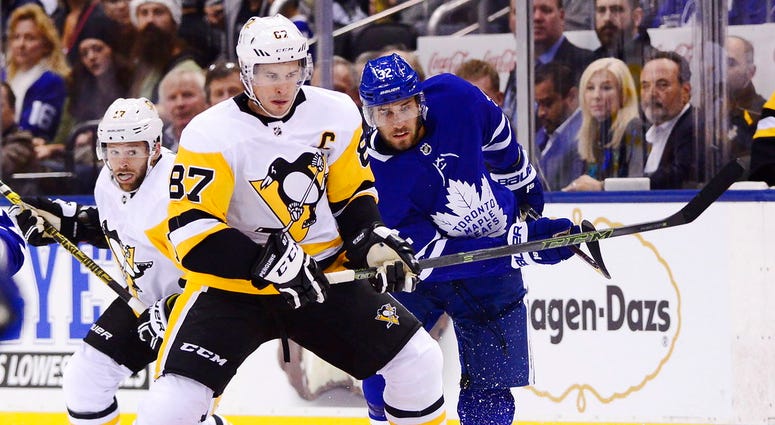 pittsburgh Penguins center Sidney Crosby (87) and Toronto Maple Leafs left wing Josh Leivo (32) battle for the puck during first period NHL hockey action in Toronto on Thursday, Oct. 18, 2018. DO NOT USE