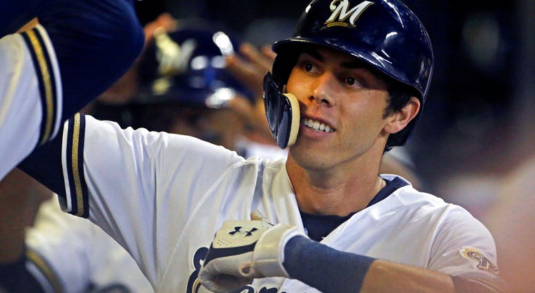 Milwaukee Brewers' Christian Yelich is congratulated by teammates in the dugout Milwaukee Brewers' Christian Yelich is congratulated by teammates in the dugout