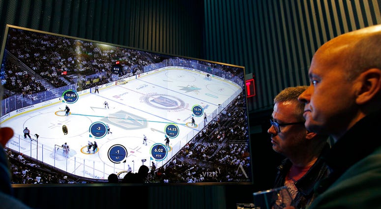 People watch real-time puck and player tracking technology on display during an NHL hockey game between the Vegas Golden Knights and the San Jose Sharks AP DO NOT USE