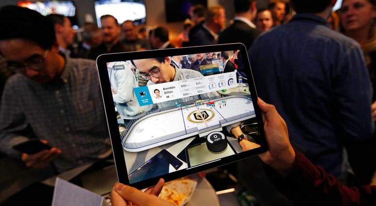 People watch real-time puck and player tracking technology on display during an NHL hockey game between the Vegas Golden Knights and the San Jose Sharks AP DO NOT USE