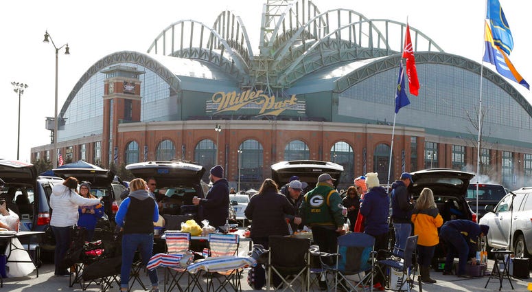 fans tailgate in the parking lot of Miller Park before a home opener baseball game between the Milwaukee Brewers and St. Louis Cardinals, in Milwaukee. AP DO NOT USE