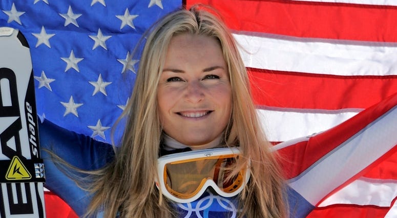 bronze medalist Lindsey Vonn of the United States hold the Stars and Stripes during the flower ceremony for the Women's super-G at the Vancouver 2010 Olympics in Whistler, British Columbia DO NOT USE