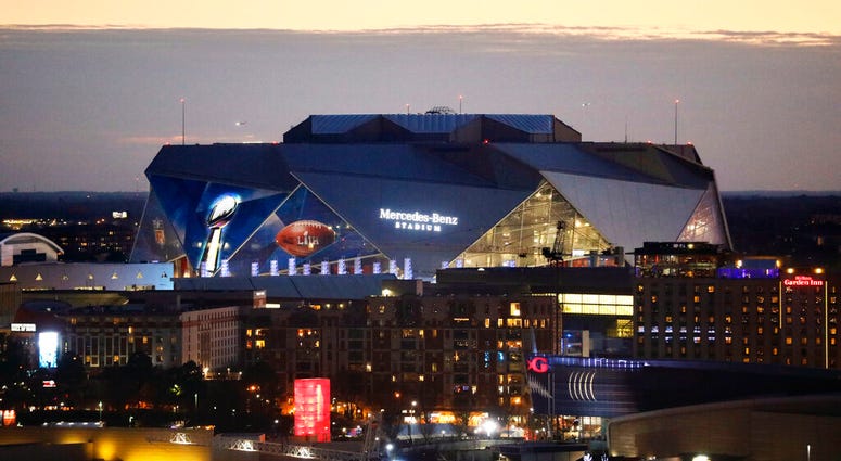 The sun sets behind Mercedes-Benz Stadium ahead of Sunday's NFL Super Bowl 53 football game between the Los Angeles Rams and New England Patriots in Atlanta, Friday, Feb. 1, 2019. DO NOT USE