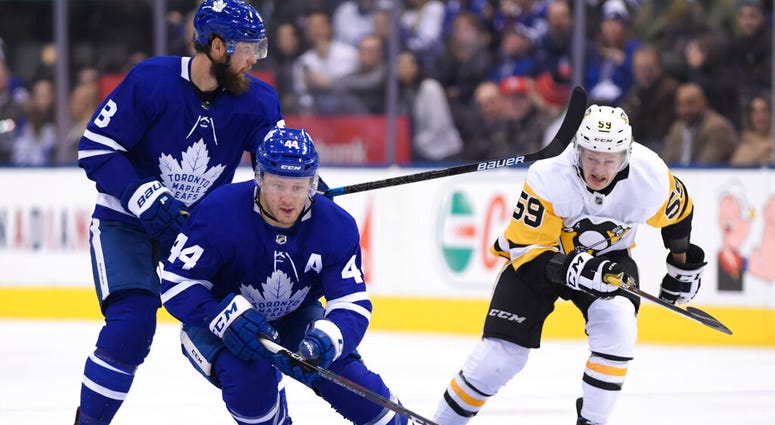 Toronto Maple Leafs defenseman Morgan Rielly (44) controls the puck as teammate Jake Muzzin (8) battles Pittsburgh Penguins left wing Jake Guentzel Toronto Maple Leafs defenseman Morgan Rielly (44) controls the puck as teammate Jake Muzzin (8) battles Pittsburgh Penguins left wing Jake Guentzel