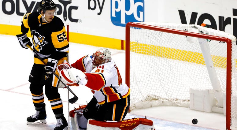 Pittsburgh Penguins' Jake Guentzel (59) defects the puck past Calgary Flames goaltender Mike Smith (41) for a goal in the first period of an NHL hockey game in Pittsburgh, Saturday, Feb. 16, 2019 Pittsburgh Penguins' Jake Guentzel (59) defects the puck past Calgary Flames goaltender Mike Smith (41) for a goal in the first period of an NHL hockey game in Pittsburgh, Saturday, Feb. 16, 2019