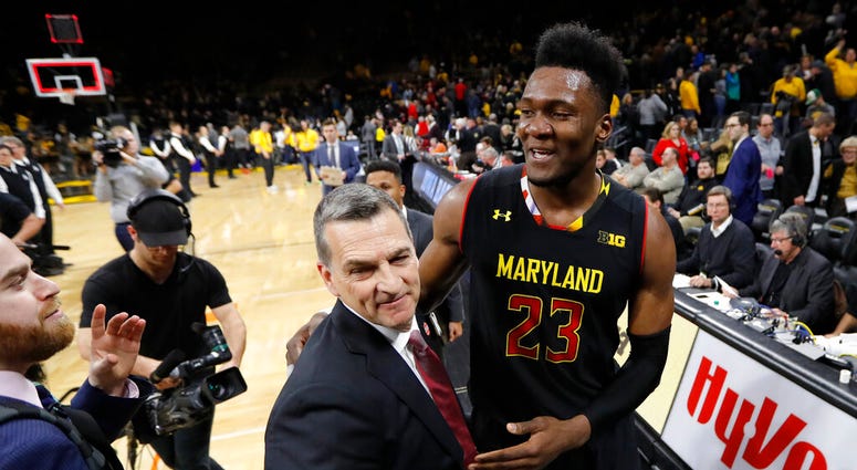 Maryland forward Bruno Fernando (23) celebrates with coach Mark Turgeon after an NCAA college basketball game against Iowa, Tuesday, Feb. 19, 2019, in Iowa City, Iowa. Maryland won 66-65. DO NOT USE