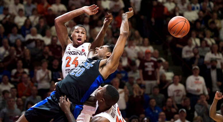 Duke center Marques Bolden (20) is fouled as Virginia Tech's Kerry Blackshear Jr. (24) and Ty Outlaw (42) defend during the first half of an NCAA college basketball game in Blacksburg, Va., Tuesday, Feb. 26, 2019. DO NOT USE