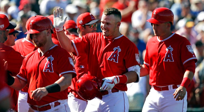 Los Angeles Angels' Mike Trout, center, is congratulated on his three-run home run against the Chicago Cubs in the third inning of a spring training baseball game Tuesday, March 5, 2019, in Tempe, Ariz. AP DO NOT USE