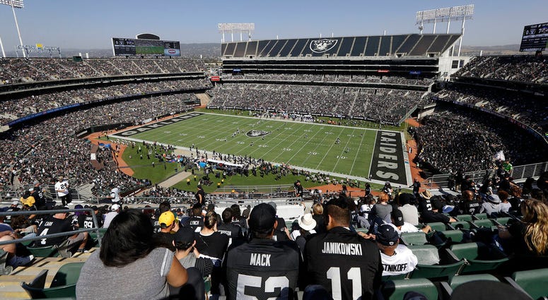 ans watch during the first half of an NFL football game between the Oakland Raiders and the Baltimore Ravens at Oakland Alameda County Coliseum in Oakland, Calif. AP DO NOT USE