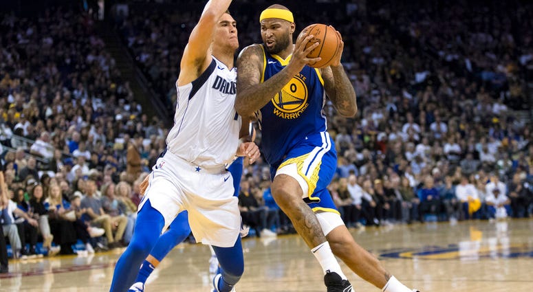 Golden State Warriors center DeMarcus Cousins, right, collides with Dallas Mavericks forward Dwight Powell in the second half of an NBA basketball game Saturday, March 23, 2019 in Oakland, Calif. AP DO NOT USE