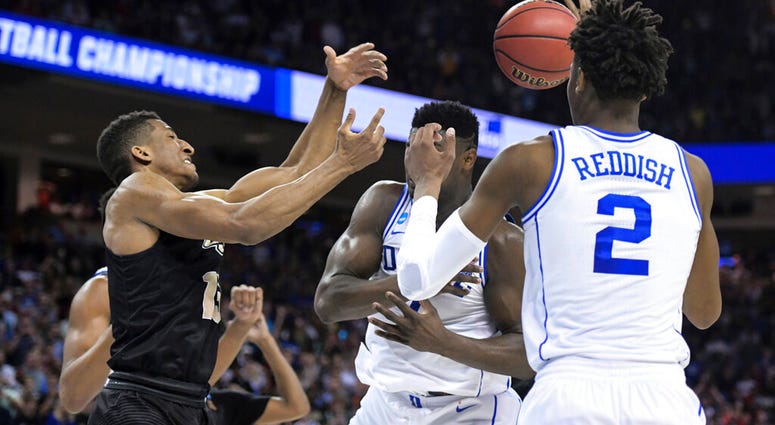 Central Florida guard Aubrey Dawkins, left, battles for a rebound against Duke's Zion Williamson, and Cam Reddish (5) after missing a potential game-winning tip-in during the second half of a second-round game AP DO NOT USE