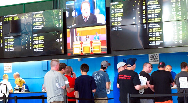 In this June 19, 2018, file photo, sports bettors line up at windows at Monmouth Park racetrack in Oceanport, N.J. AP DO NOT USE