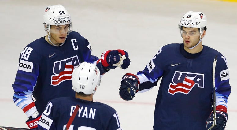 Alex Debrincat of the US, right, celebrates with teammates Patrick Kane, left, and Derek Ryan, center, after scoring his sides fourth goal during the Ice Hockey World Championships group A match between the United States and Great Britain AP DO NOT USE