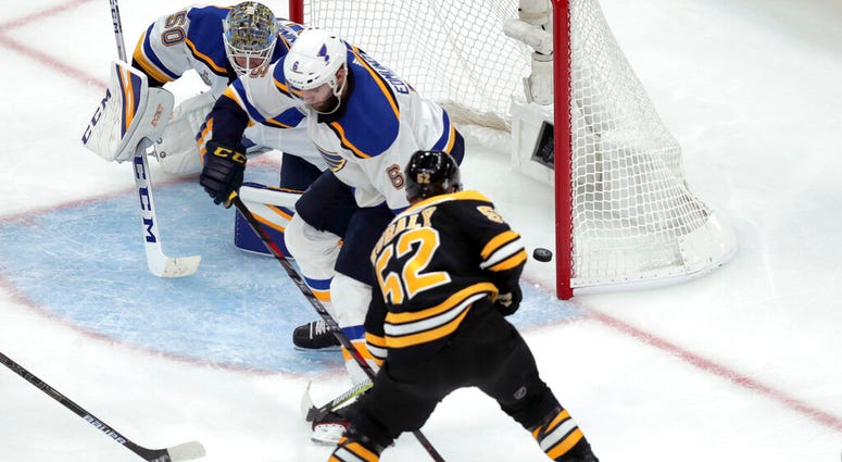Boston Bruins' Sean Kuraly (52) scores a goal past St. Louis Blues goaltender Jordan Binnington (50) and Joel Edmundson (6) during the third period in Game 1 of the NHL hockey Stanley Cup Final, Monday, May 27, 2019, in Boston. ap do not use