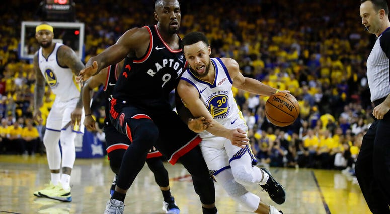 Golden State Warriors guard Stephen Curry (30) dribbles against Toronto Raptors center Serge Ibaka (9) during the second half of Game 3 of basketball's NBA Finals in Oakland, Calif AP DO NOT USE