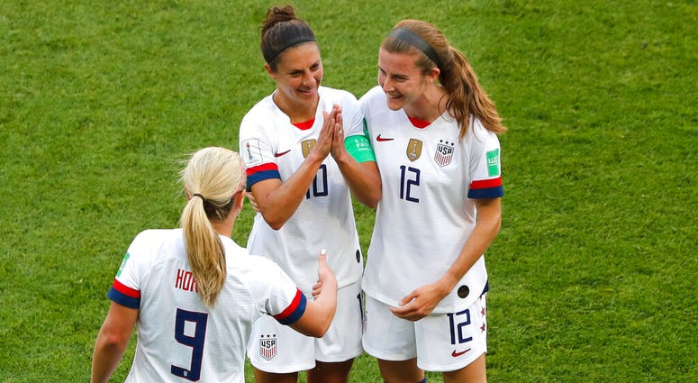 United States' Carli Lloyd , center, celebrates with Lindsey Horan and Tierna Davidson, right, after scoring the opening goal during the Women's World Cup Group F soccer match between the United States and Chile at the Parc des Princes in Paris, Sunday, J AP DO NOT USE
