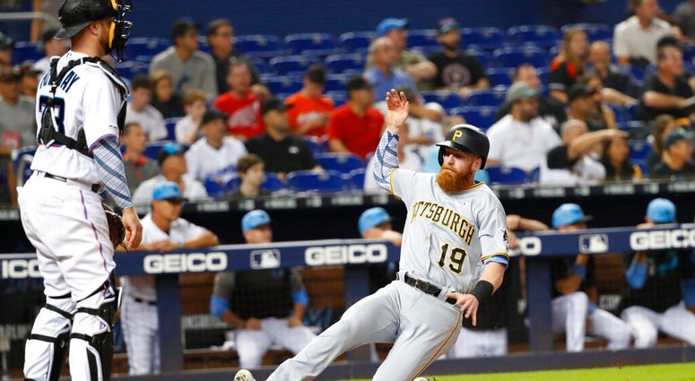 Pittsburgh Pirates' Colin Moran (19) slides into home as Miami Marlins catcher Bryan Holaday looks on during the fourth inning of a baseball game, Sunday, June 16, 2019, in Miami. Moran scored on a double by Jung Ho Kang. Pittsburgh Pirates' Colin Moran (19) slides into home as Miami Marlins catcher Bryan Holaday looks on during the fourth inning of a baseball game, Sunday, June 16, 2019, in Miami. Moran scored on a double by Jung Ho Kang.