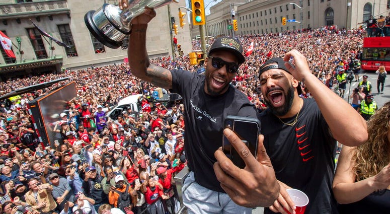 Toronto Raptors' Kawhi Leonard holds his MVP trophy while celebrating with rapper/producer Drake during the team's NBA basketball championship parade in Toronto, Monday, June 17, 2019. AP DO NO TUSE