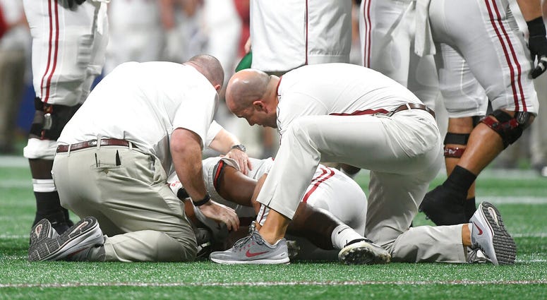Alabama quarterback Tua Tagovailoa (13) is helped by medical staff during the second half of the Southeastern Conference championship NCAA college football game against Georgia, in Atlanta AP DO NOT USE