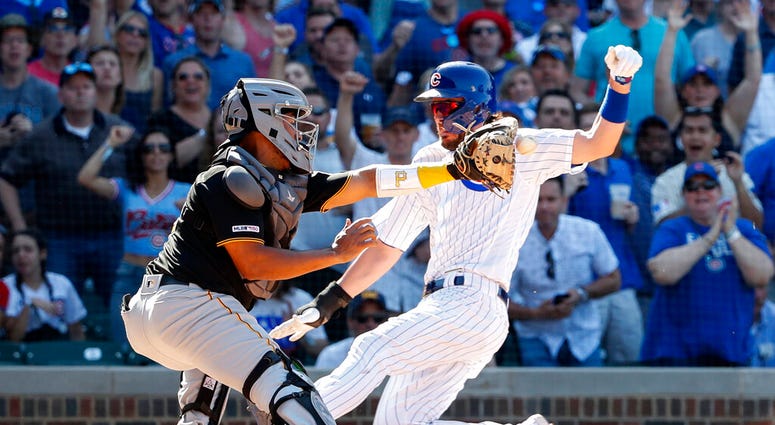 Chicago Cubs' Kris Bryant, right, scores against Pittsburgh Pirates' Jacob Stallings, left, during the eighth inning of a baseball game, Friday, July 12, 2019, in Chicago. Chicago Cubs' Kris Bryant, right, scores against Pittsburgh Pirates' Jacob Stallings, left, during the eighth inning of a baseball game, Friday, July 12, 2019, in Chicago.