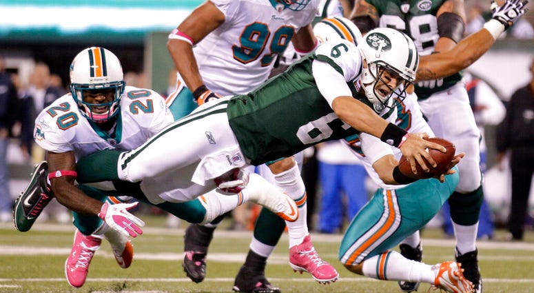 In this Oct. 17, 2011, file photo, New York Jets quarterback Mark Sanchez (6) dives away from Miami Dolphins free safety Reshad Jones (20) for a touchdown during the second quarter of an NFL football game, in East Rutherford, N.J. AP DO NOT USE