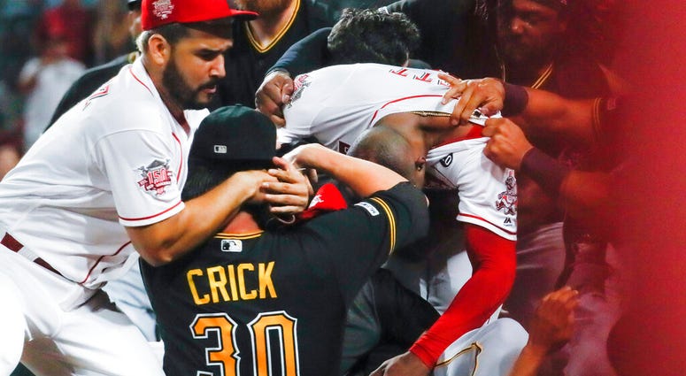 Pittsburgh Pirates' Kyle Crick (30) and Cincinnati Reds' Eugenio Suarez, left, and Amir Garrett, center right, are part of a brawl during the ninth inning of a baseball game Tuesday, July 30, 2019, in Cincinnati.