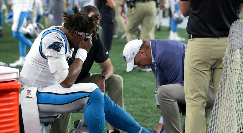 Carolina Panthers quarterback Cam Newton (1) receives attention on the sideline after an injury Carolina Panthers quarterback Cam Newton (1) receives attention on the sideline after an injury